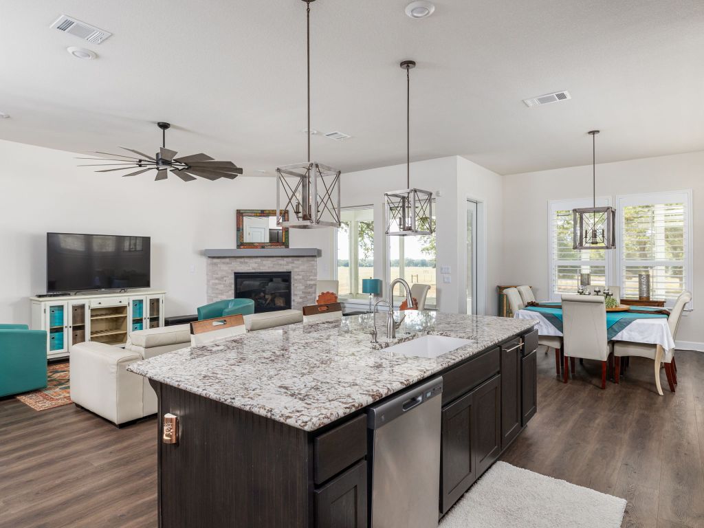 1145 West County Road East Lexington, TX 78947 - Photo 33 of 34 a view of kitchen island with granite countertop living room space with furniture flat screen tv