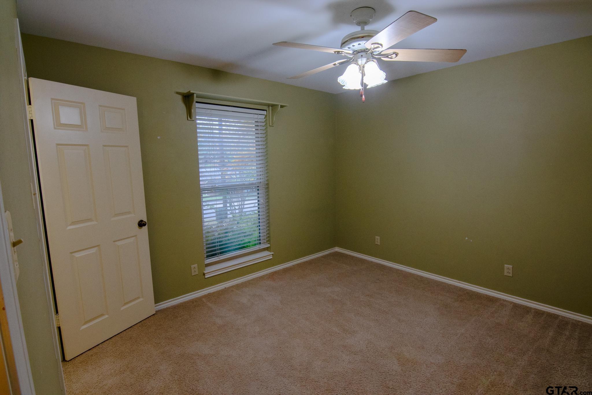 818 Beth Drive Tyler, TX 75703 - Photo 16 of 24 an empty room with a chandelier fan and windows