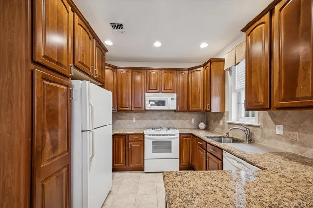 a kitchen with stainless steel appliances granite countertop a refrigerator a stove a sink and a microwave