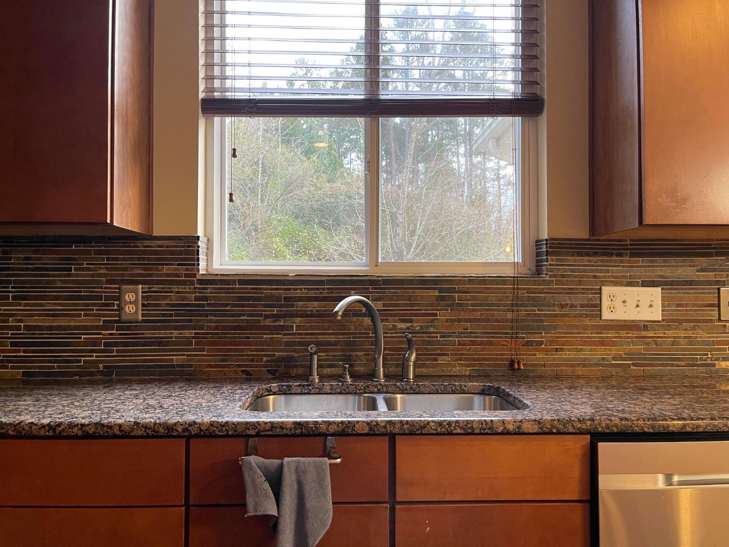 a kitchen with granite countertop sink and window