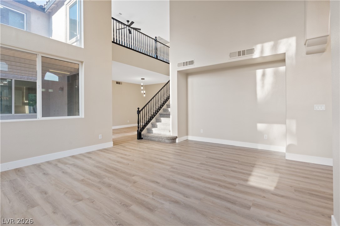 1662 Ravanusa Drive Henderson, NV 89052 - Photo 6 of 74 A spacious living area with tall windows and light wood-look flooring invites natural illumination.