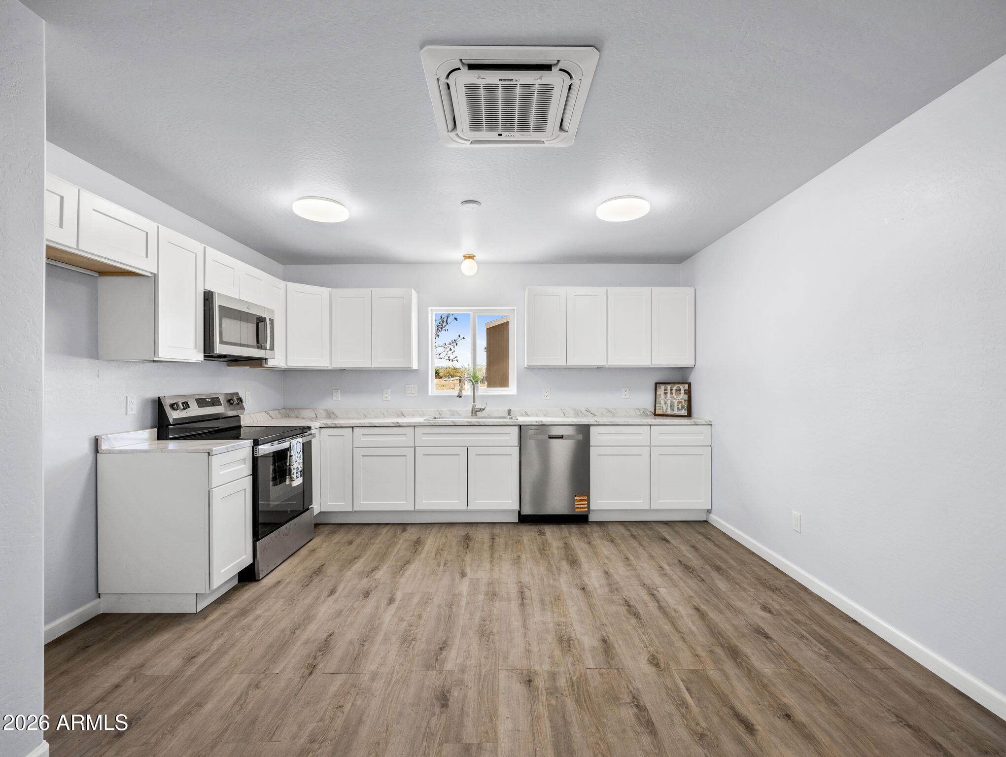 18278 Frontier Road Peeples Valley, AZ 86332 - Photo 16 of 31 a kitchen with a white cabinets and wooden floor