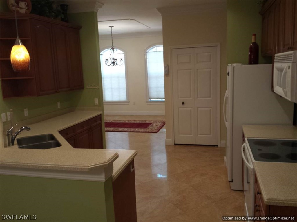 8448 Grove Road Fort Myers, FL 33967 - Photo 10 of 23 a kitchen that has a sink and a stove in it