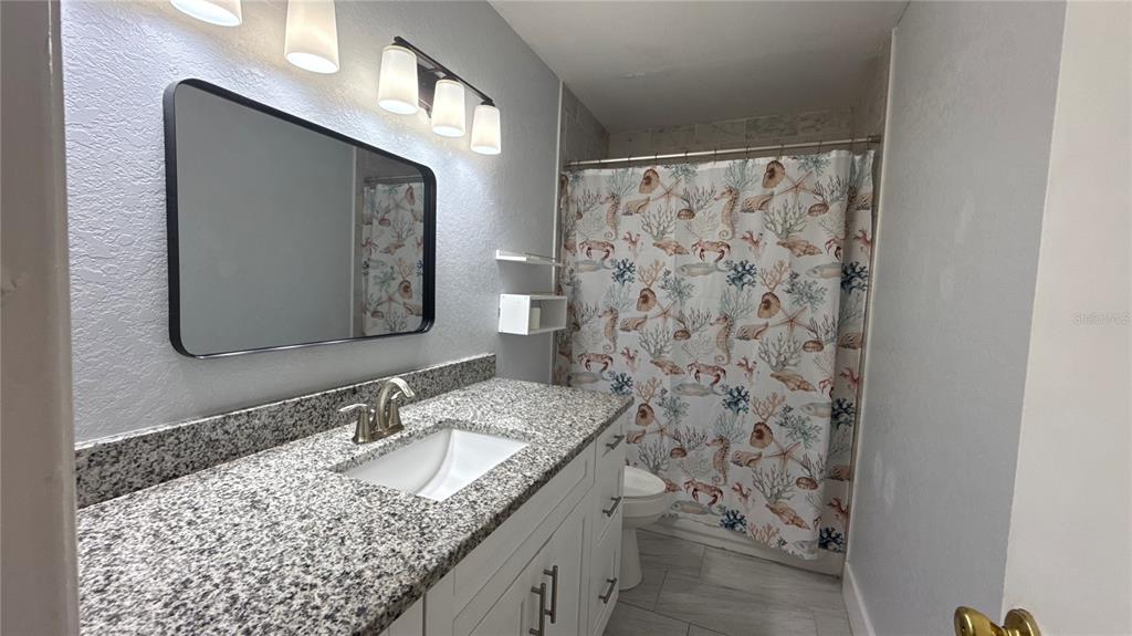 8106 Wichita Way Tampa, FL 33619 - Photo 14 of 21 a bathroom with a granite countertop sink and a mirror