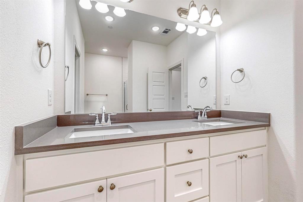 336 Buck Ridge Drive Frisco, TX 75068 - Photo 21 of 40 a bathroom with a granite countertop double vanity sink and a mirror