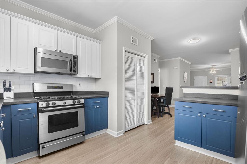 3675 Peachtree Road Northeast, Unit 45 Atlanta, GA 30319 - Photo 12 of 42 a kitchen with stainless steel appliances a stove a microwave and cabinets