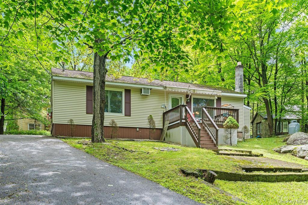 a view of a house with a yard and large tree