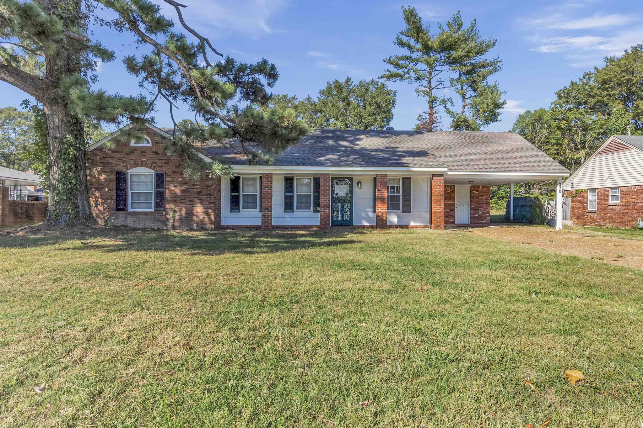 a front view of a house with a garden and trees