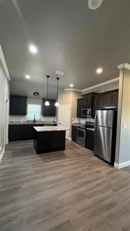 a large kitchen with kitchen island a sink stainless steel appliances and cabinets