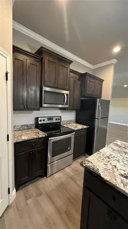 a kitchen with stainless steel appliances granite countertop a stove refrigerator and microwave