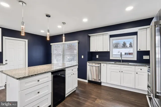 a large kitchen with granite countertop a sink stainless steel appliances and cabinets