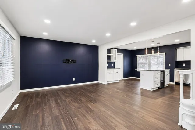a view of kitchen with refrigerator and wooden floor