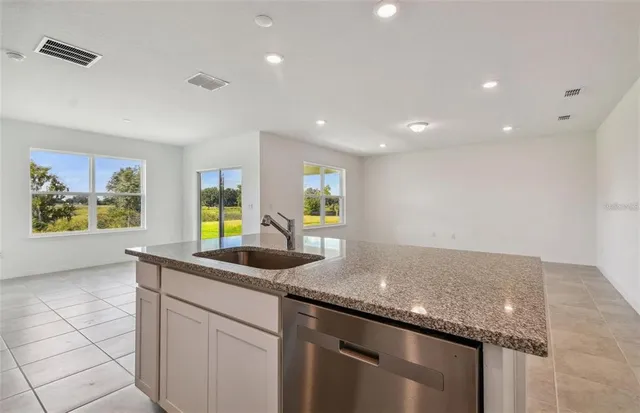 a kitchen with granite countertop kitchen island a sink and a large window