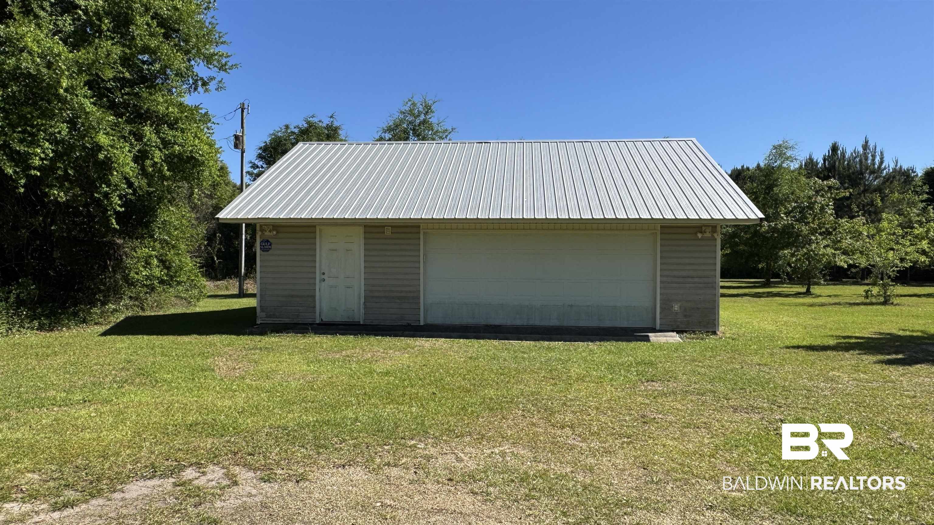 33370 Highway 98 Lillian, AL 36549 - Photo 13 of 58 Detached garage structure featuring a metal roof and light-colored siding
