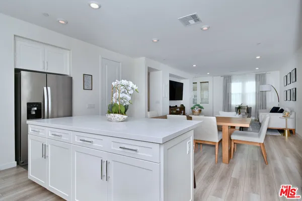 a kitchen with white cabinets and counter space