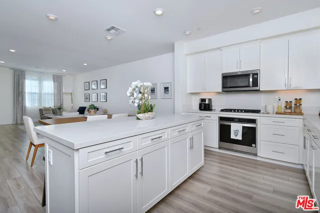 a kitchen with white cabinets stainless steel appliances and sink