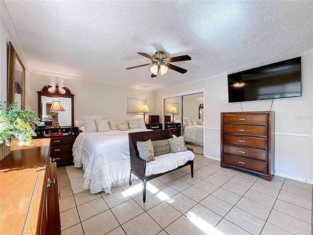 a spacious bedroom with a large bed and a chandelier
