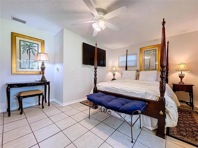 a bedroom with a large bed and a chandelier