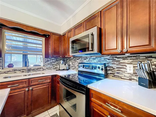 a kitchen with stainless steel appliances granite countertop a sink a stove and a refrigerator