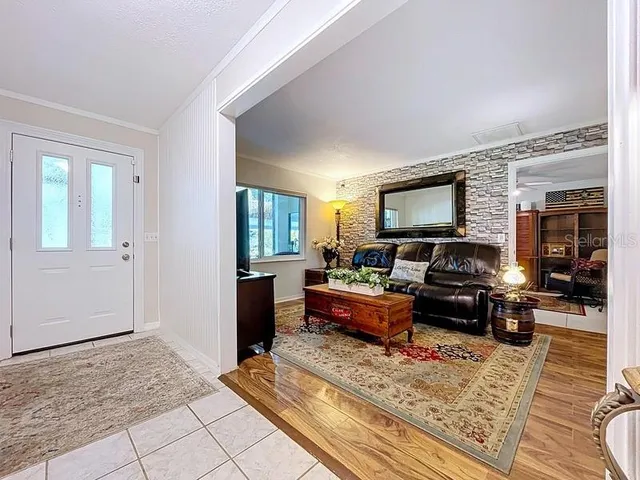 a living room with furniture flat screen tv and window