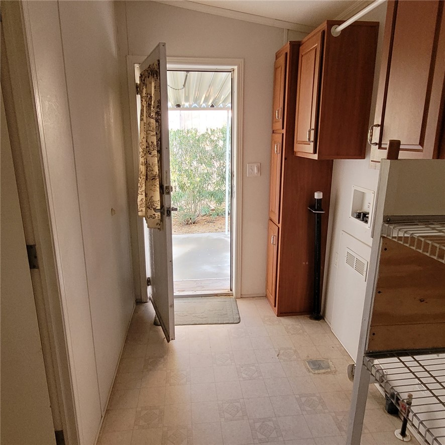 9732 2nd Street Chloride, AZ 86431 - Photo 16 of 28 This utility area features patterned flooring, built-in wooden cabinetry providing storage, and an exterior door with a view of outdoor foliage