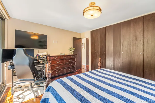 a bedroom with a bed and a flat tv screen on dresser