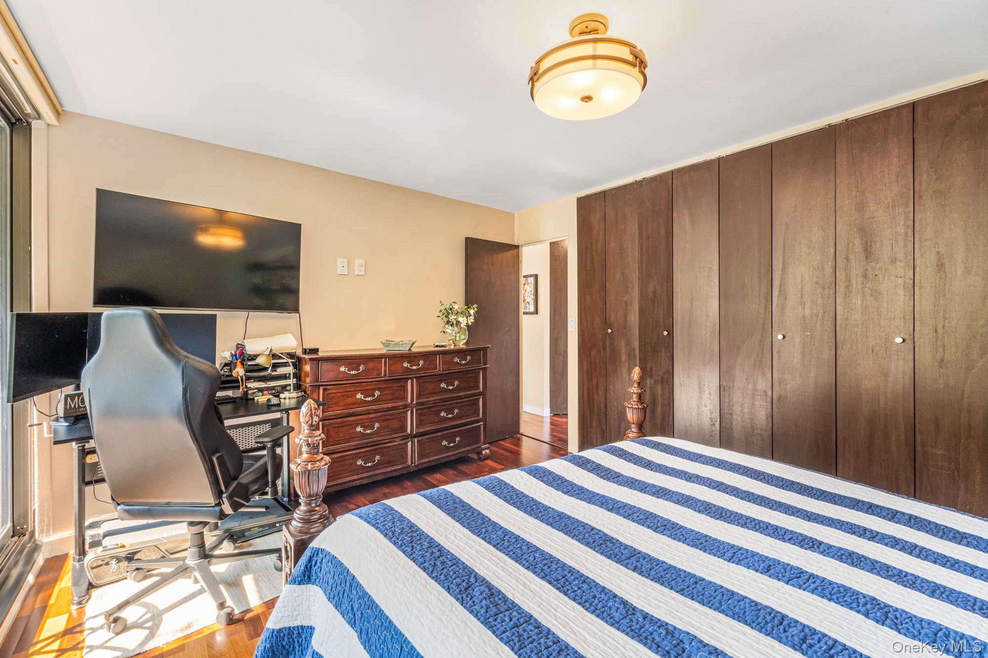 168-01 12th Avenue, Unit 3A Queens, NY 11357 - Photo 15 of 22 a bedroom with a bed and a flat tv screen on dresser