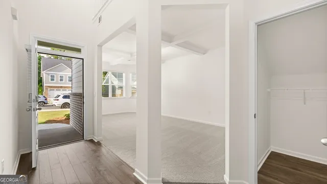 a view of a hallway with wooden floor and a living room