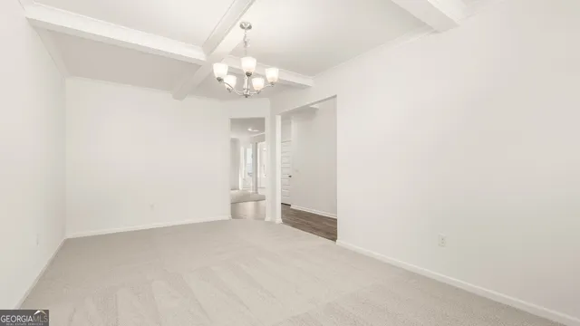 a view of an empty room with a chandelier fan