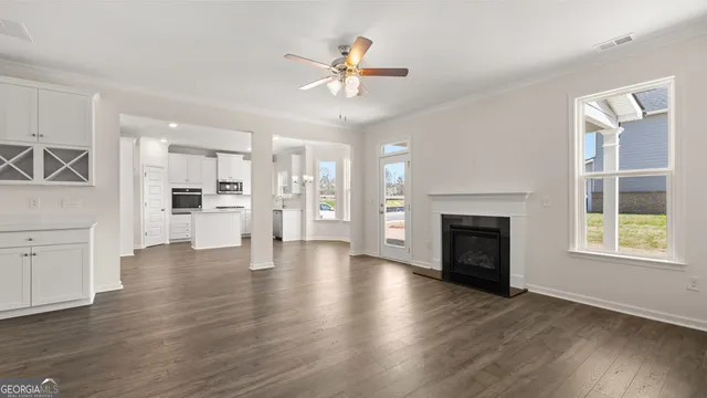 a view of an empty room with a kitchen and a fireplace