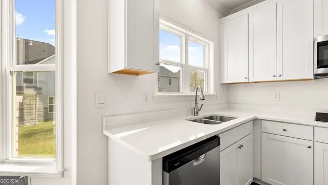 a kitchen with stainless steel appliances cabinets a sink and a window