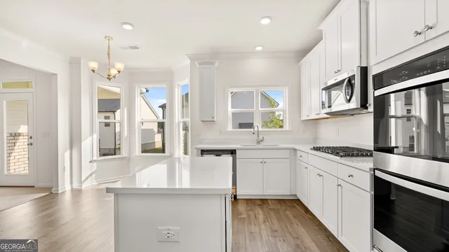 a kitchen with stainless steel appliances granite countertop a stove and cabinets