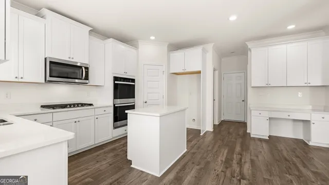 a kitchen with cabinets stainless steel appliances and wooden floor