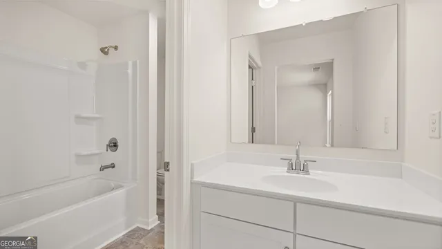 a bathroom with a sink double vanity granite tub shower and a mirror