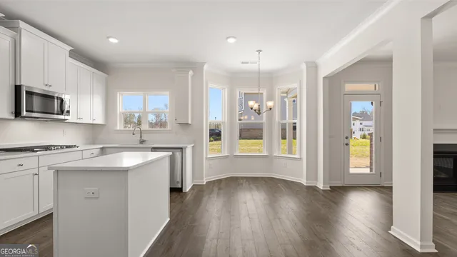 a kitchen with wooden floors and appliances