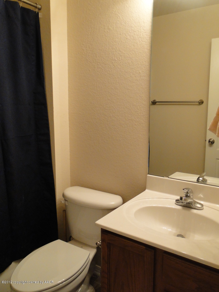 4805 Nimbus Lane Amarillo, TX 79110 - Photo 14 of 15 a white toilet sitting next to a bathroom sink