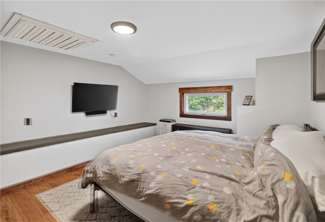 130 Maggie Rufus Lane Westminster, SC 29693 - Photo 21 of 50 Warm hardwood flooring grounds this inviting bedroom, featuring a bright window overlooking green trees.