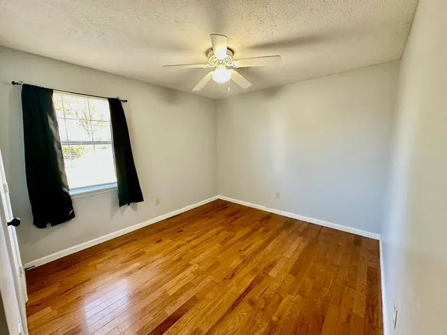 a view of a room with wooden floor and fan