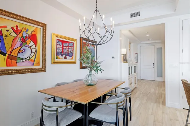 a view of a dining room with furniture a chandelier and wooden floor