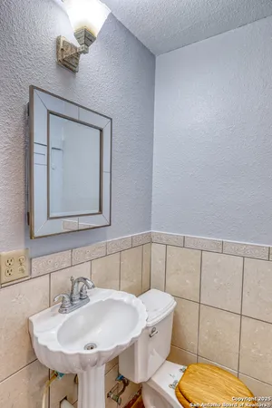a bathroom with a sink mirror and toilet