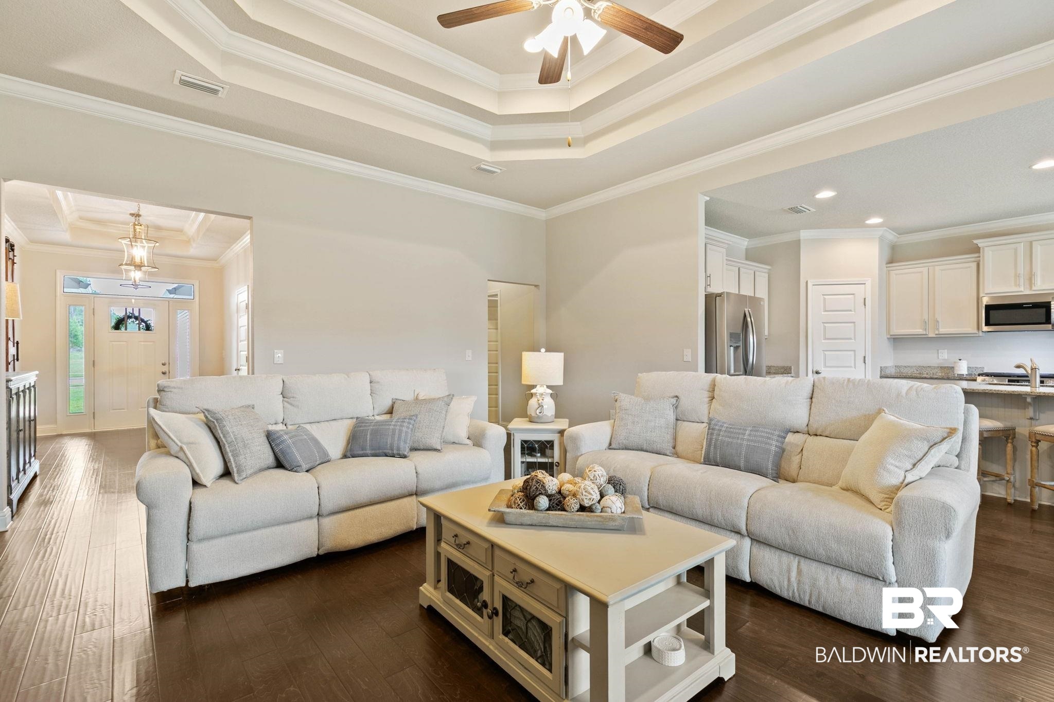 31187 Spoonbill Road Daphne, AL 36527 - Photo 12 of 85 Living area featuring a tiered tray ceiling with crown molding, wood-finish flooring, and recessed lighting