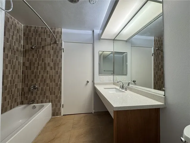 a bathroom with a sink mirror toilet and bathtub