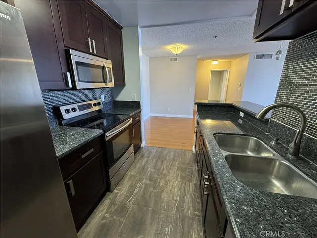 a kitchen with granite countertop a sink and a stove top oven