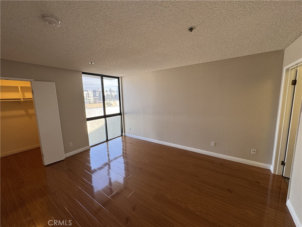 222 South Central Avenue, Unit 214 Los Angeles, CA 90012 - Photo 6 of 21 an empty room with wooden floor and windows