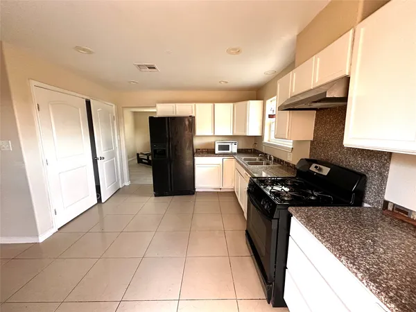 a kitchen with a stove a refrigerator and a sink