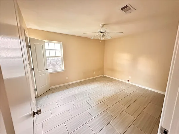 an empty room with windows and fan