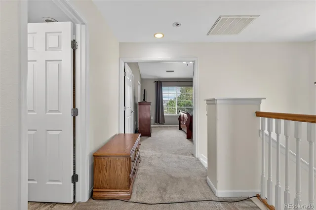 a view of a hallway with a furniture and a living room