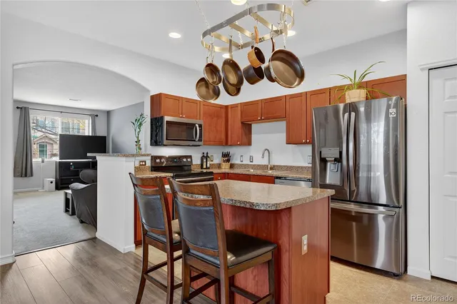 a kitchen with stainless steel appliances granite countertop a stove refrigerator and microwave
