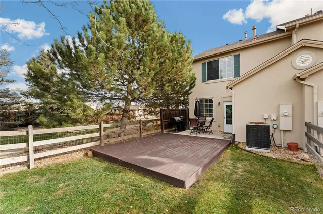 a view of a house with backyard and a tree