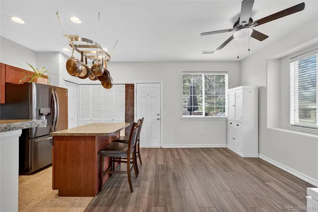 an open kitchen with wooden floor and stainless steel appliances